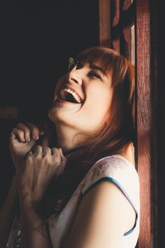 A woman laughing joyfully as a butterfly lands on her nose, captured in São Paulo, Brazil.